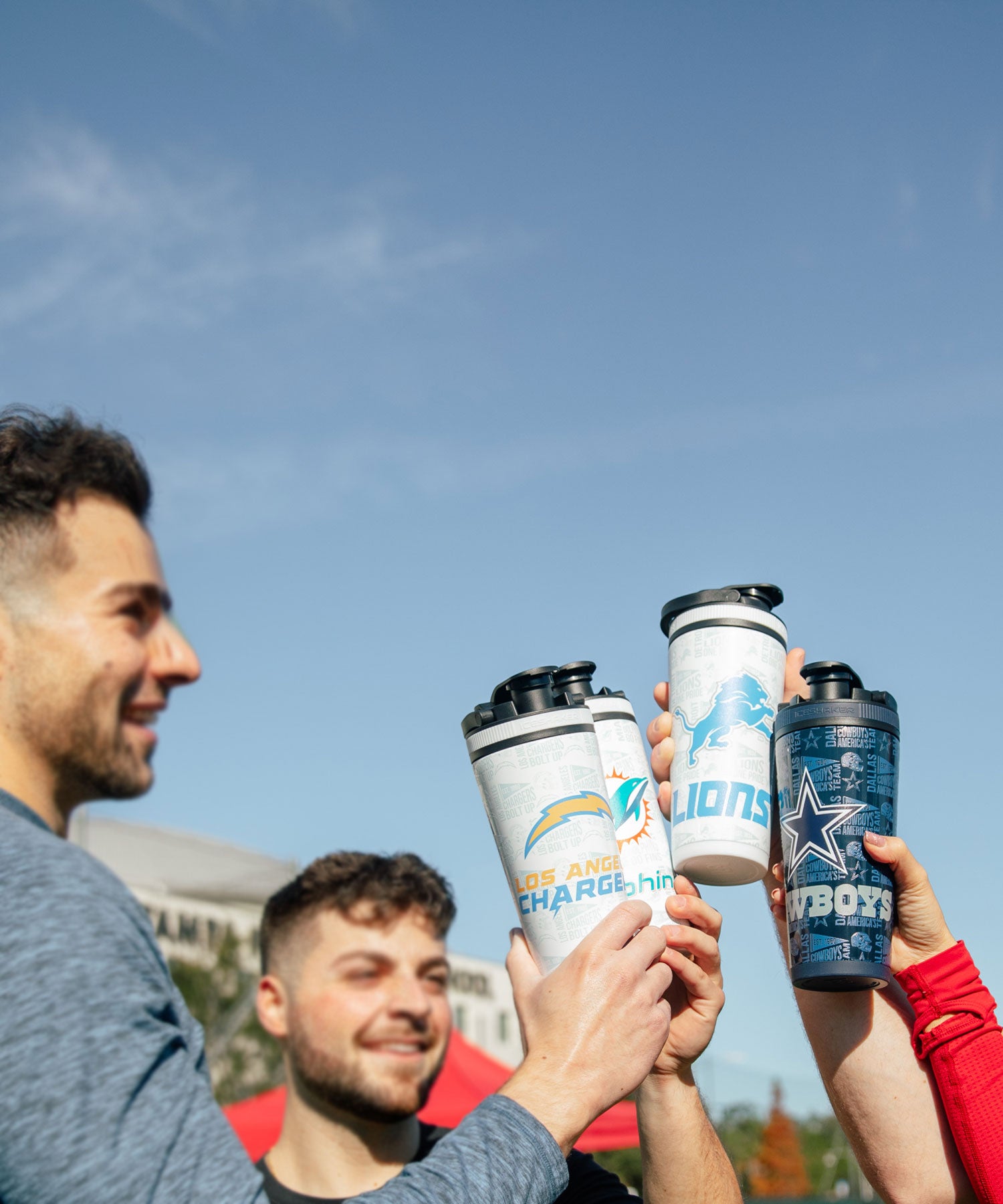 A group of young adults holding up 4 different Ice Shaker 4D-wrapped NFL bottles by Ice Shaker.