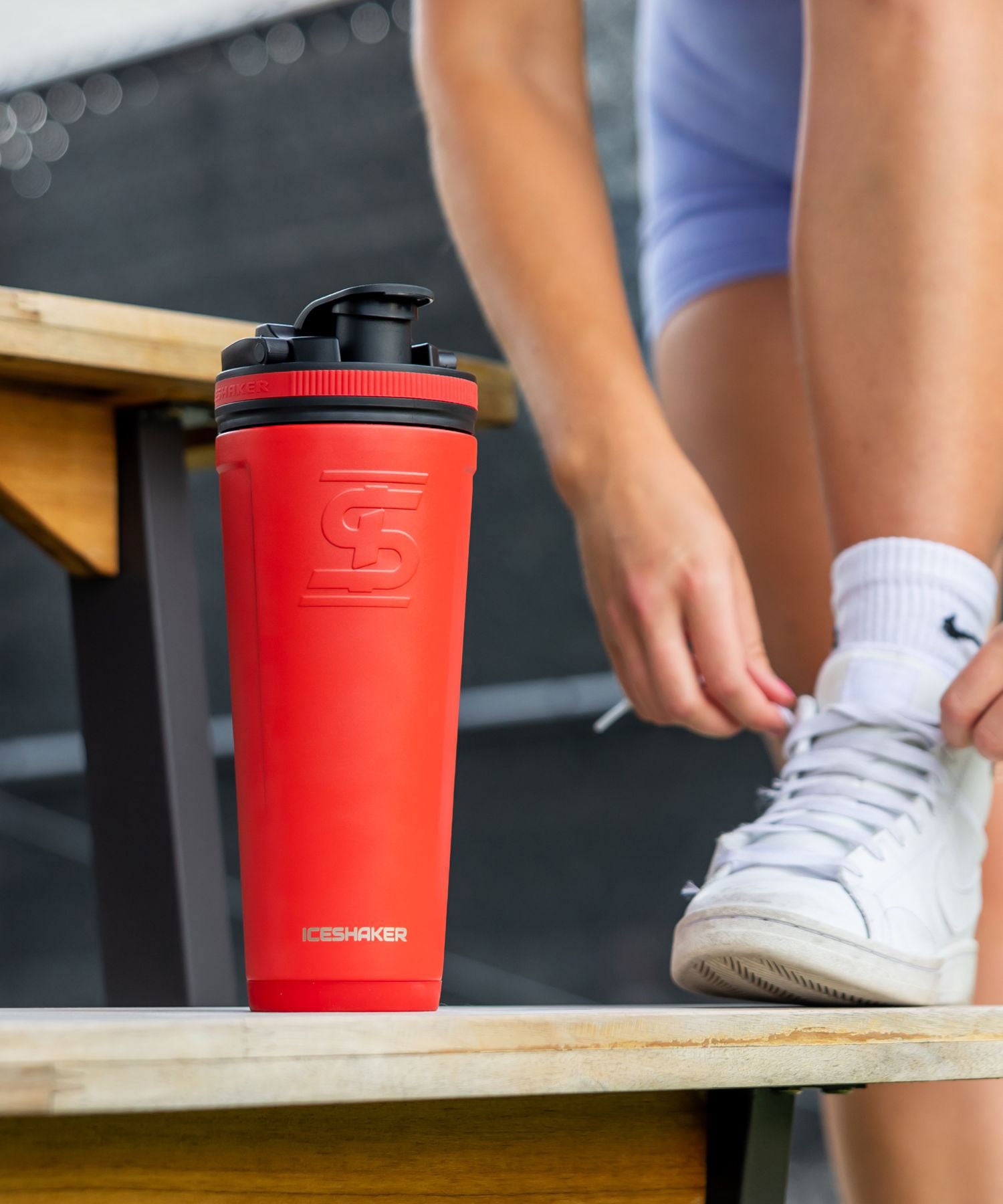 a red 36oz ice shaker on a picnic table. 