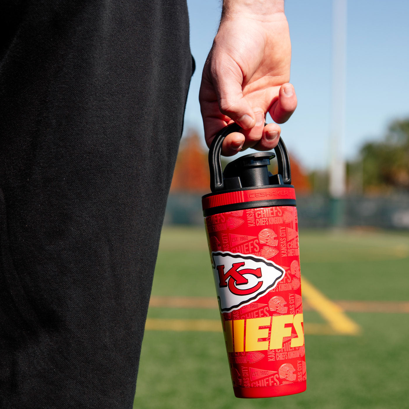 a Kansas City Chiefs 4D Ice Shaker being carried by its handle that's built into the lid.