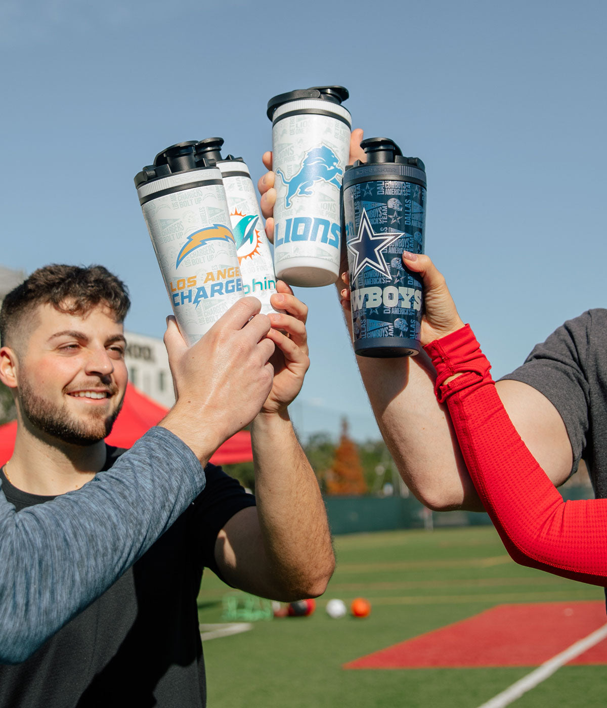 a group of people holding various 4D NFL Ice Shakers on a field.