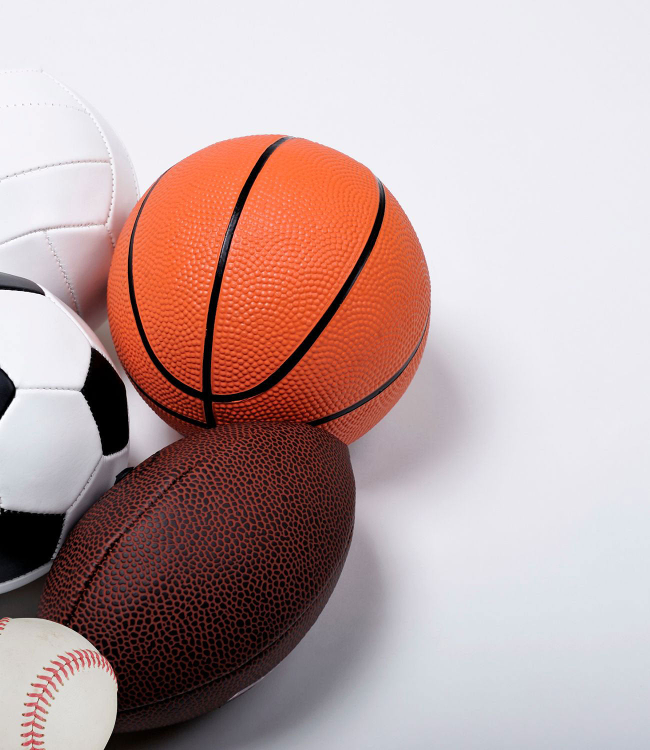 a group of sports balls (basketball, soccer ball, baseball, football, & volleyball) grouped together on a white background